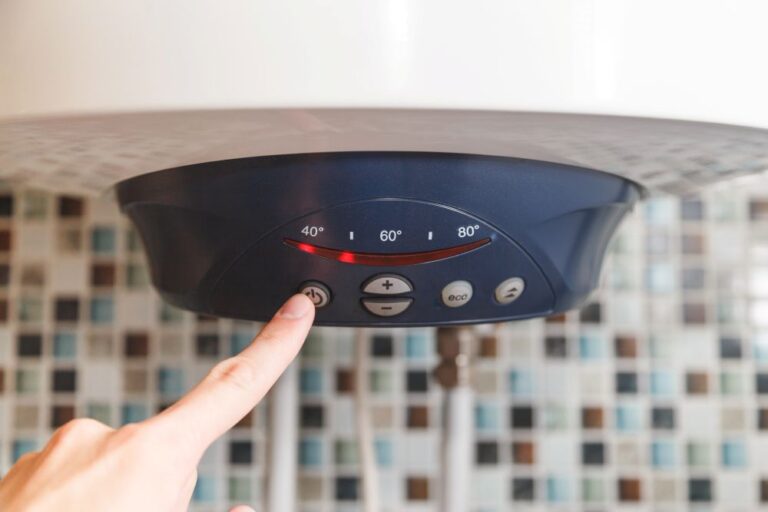 una mano che regola la temperatura dello Scaldabagno elettrico