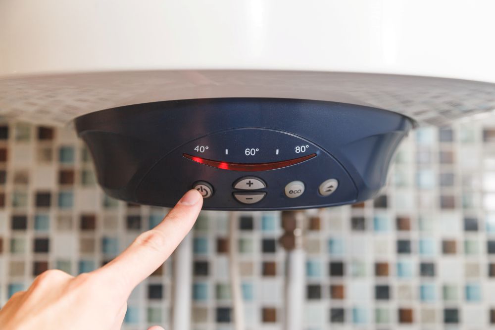 una mano che regola la temperatura dello Scaldabagno elettrico